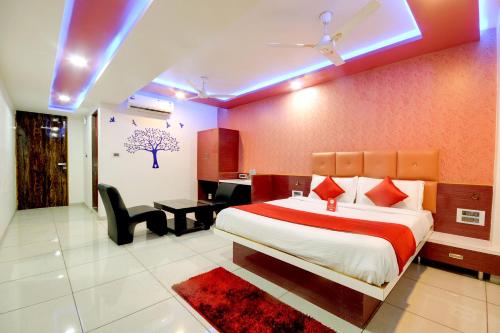 a bedroom with a large bed and a desk and chair at Hotel Hillton in Gandhinagar