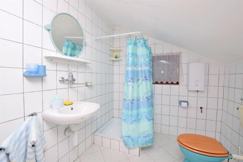 a bathroom with a toilet and a sink and a shower curtain at Apartments Katarina in Pirovac