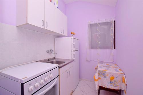 a small kitchen with a sink and a stove at Apartments Katarina in Pirovac