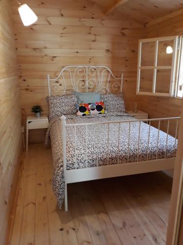 a bedroom with a white bed in a log cabin at Cyprus Glamping Park in Ayios Theodhoros