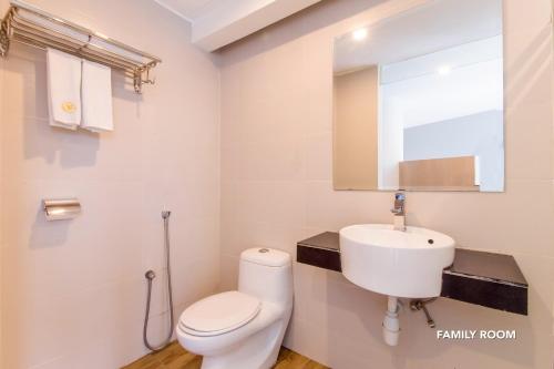 a white bathroom with a toilet and a sink at De Elements Business Hotel KL in Kuala Lumpur