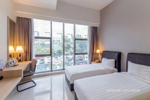 a hotel room with two beds and a window at De Elements Business Hotel KL in Kuala Lumpur