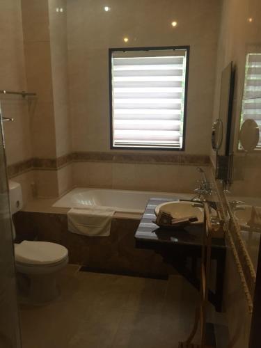 a bathroom with a tub and a toilet and a sink at Seasons Riverside Hotel in Vientiane
