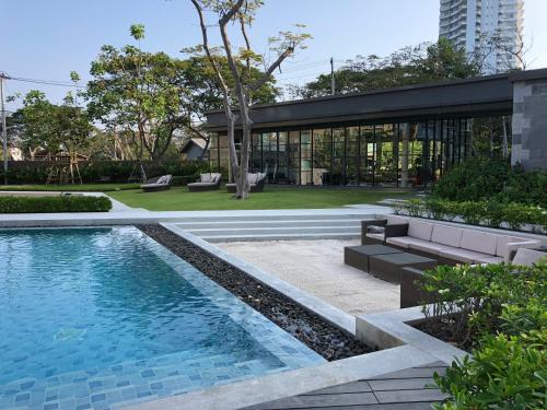 a swimming pool in a yard with a building at rain condo Cha-am 2 bedroom by Napa in Cha Am
