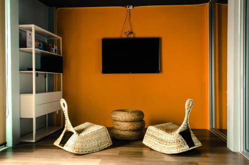 a living room with two baskets and a television at Whereder Poshtel in Udon Thani