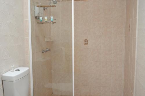 a shower stall with a toilet in a bathroom at Mid City Motor Inn in Gladstone