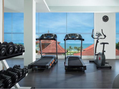 a gym with cardio equipment and a large window at Holiday Inn Express Baruna by IHG in Kuta