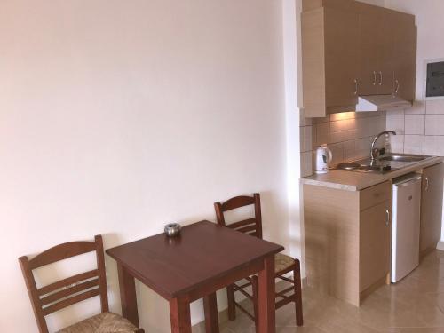a kitchen with a table and chairs and a sink at TO VOTSALO-beach side studios & taverna in Karpathos Town
