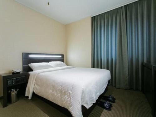 Ένα ή περισσότερα κρεβάτια σε δωμάτιο στο Busan Tourist Hotel