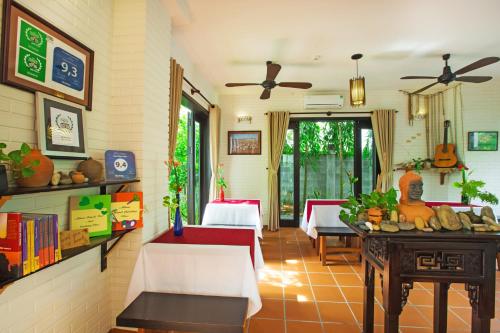 a living room with a table and some chairs at East West Villa in Hoi An