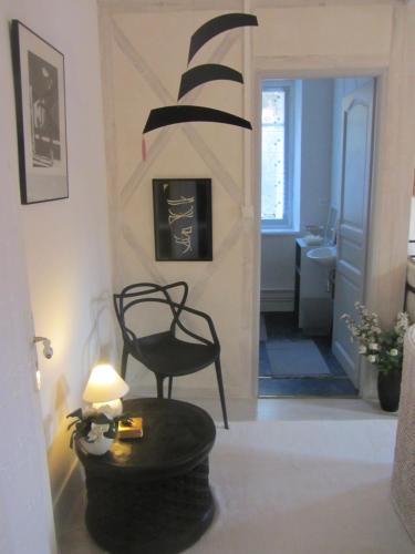 a living room with a black chair and a table at La Maison de Natasha in Castillon-en-Couserans