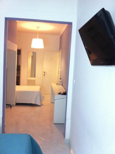 a living room with a bed and a flat screen tv at Residencial Valentina in Lisbon