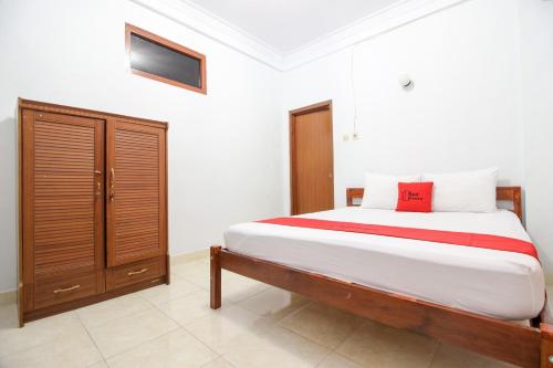 a bedroom with a bed and a cabinet in it at RedDoorz Plus near Alun Alun Selatan in Yogyakarta