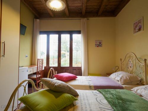 two beds in a room with a window at B&B Gassa d'Amante in Capoterra