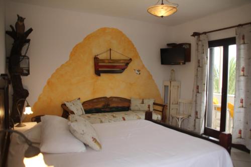 a bedroom with a bed with a large rock wall at Villa Danai in Agia Anna Naxos