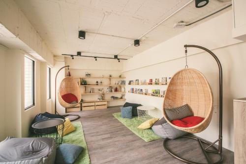 a room with two hanging chairs in a room at Stray Birds Taichung Hostel in Taichung