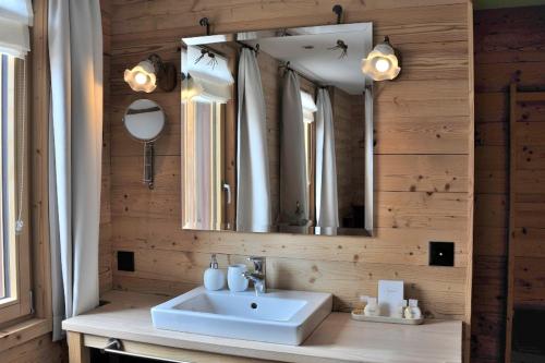a bathroom with a sink and a mirror at Hotel Chesa Staila in La Punt-Chamues-ch
