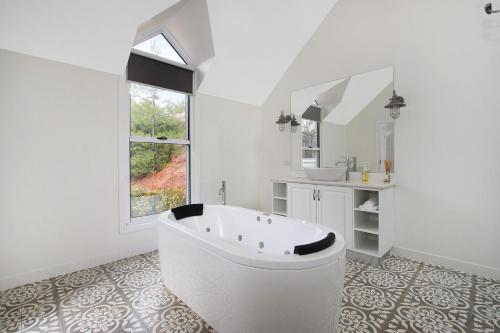 a white bathroom with a tub and a sink at Beyond Bliss - Guesthouse 1 in Bright