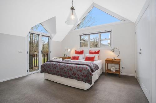 a bedroom with a bed with red pillows and a window at Beyond Bliss - Guesthouse 2 in Bright