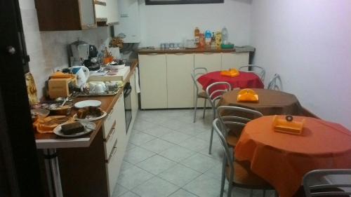 una cocina con 2 mesas y sillas y una cocina con encimera en Raggio di Sole, en Rende