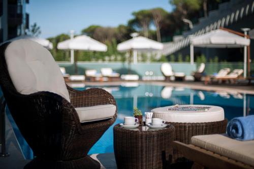 - une piscine avec des chaises et une table avec des tasses dans l'établissement Somerset Maslak Istanbul, à Istanbul