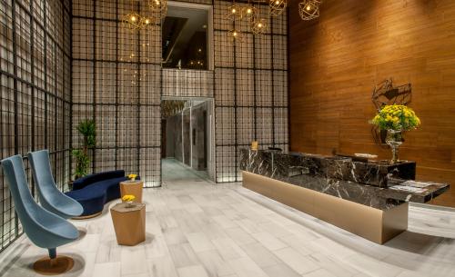 a lobby with a blue chair and a counter at Somerset Maslak Istanbul in Istanbul