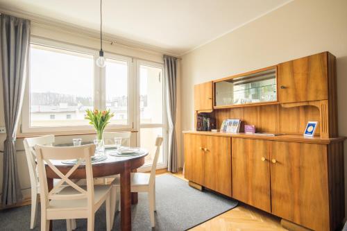 a dining room with a table and a large window at Sea You Apartments- Malczewskiego in Sopot