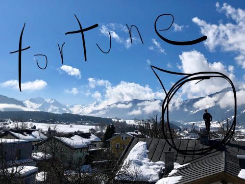 a man standing on top of a roof in the snow at Atelierwohnung Jirana in Saalfelden am Steinernen Meer
