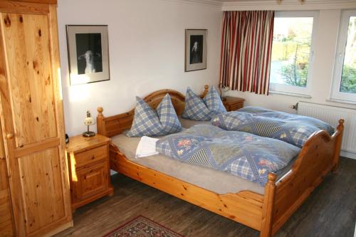 フーズムにある"Haus Husum"のベッドルーム1室(木製ベッド1台、青い枕付)