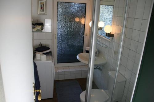 フーズムにある"Haus Husum"のバスルーム(洗面台、トイレ付)、窓が備わります。