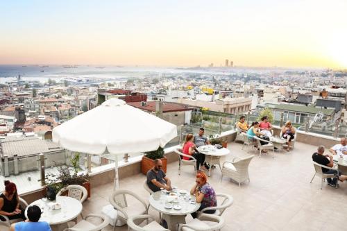 a group of people sitting at tables on a roof at Benler Otel Laleli ISTanbul in Istanbul