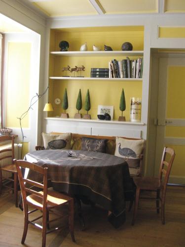 a dining room with a table with chairs and shelves at Hôtel de la Chaux-d'Abel in La Ferrière