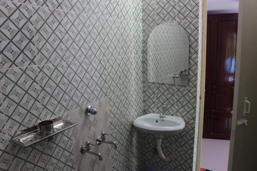 y baño con lavabo y espejo. en Puthenchirayil Homestay en Thiruvananthapuram