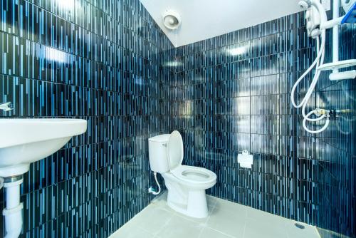 a bathroom with a white toilet and a sink at Ivy Cottage by Qiu in Sara Buri