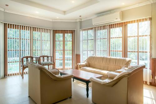 a living room with a couch and a table at Ivy Cottage by Qiu in Sara Buri