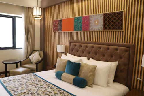 a bedroom with a large bed with pillows at Radisson Srinagar in Srinagar
