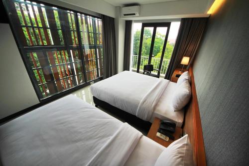 a hotel room with two beds and a window at Hay Bandung in Bandung