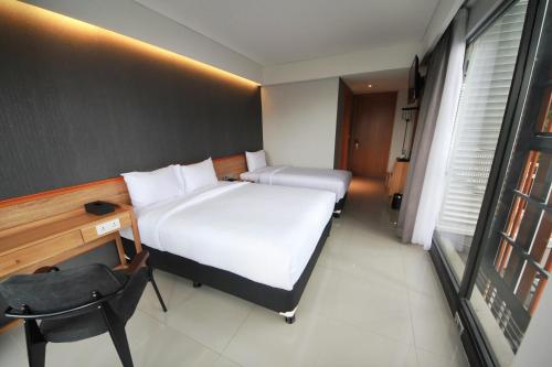 a bedroom with two beds and a desk and a chair at Hay Bandung in Bandung