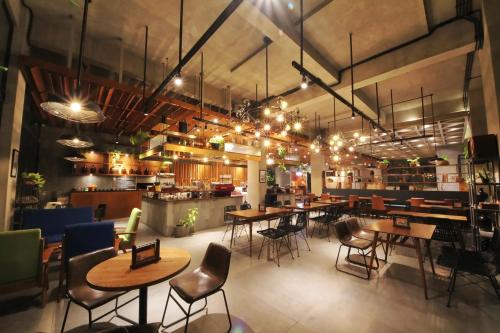 a restaurant with tables and chairs in a room at Hay Bandung in Bandung