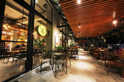 a dining room with tables and chairs in a restaurant at Hay Bandung in Bandung