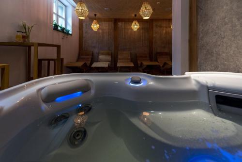 a bath tub with a blue light in a room at Fidelitas Hotel in Sfântu-Gheorghe