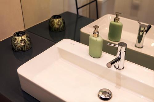 a bathroom sink with soap dispensers on top of it at "Scandinavian" apartment in Cascais's old town in Cascais