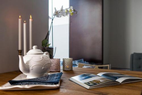 a table with a tea pot and a book on it at "Scandinavian" apartment in Cascais's old town in Cascais