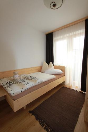 a bedroom with a wooden bed with a window at Gästehaus Waldrand Garni in Wiesing