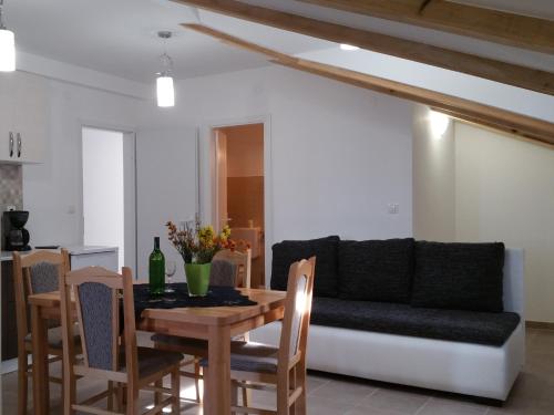 ein Wohnzimmer mit einem Tisch und einem Sofa in der Unterkunft Apartmani Marijana in Šibenik