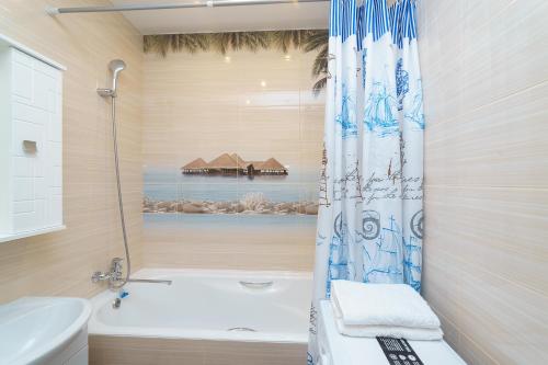 a bathroom with a shower curtain and a bath tub at Шахтеров, 74Б in Kemerovo