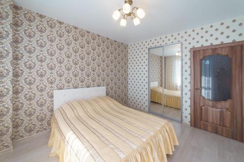 a bedroom with a bed and a mirror at Шахтеров, 74Б in Kemerovo