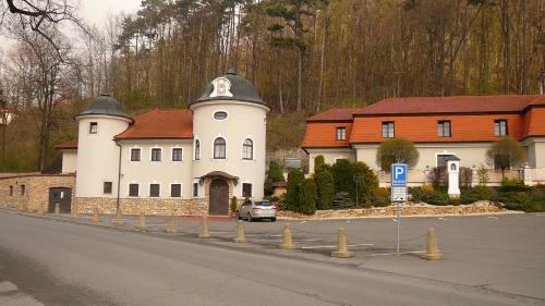 a large white building with red roofs on a street at Hotel Zámeček Pod Hradem Starý Jičín 111 in Starý Jičín