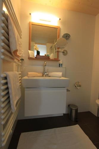 a bathroom with a white sink and a mirror at Gästehaus Waldrand Garni in Wiesing