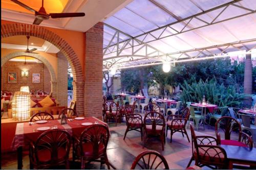a dining room with tables and chairs and a patio at Mango Hill Pondicherry in Pondicherry